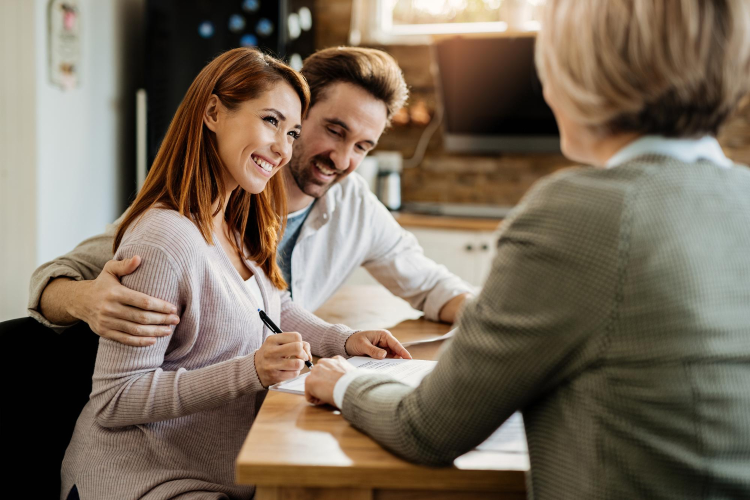 young-happy-woman-her-husband-signing-agreement-with-insurance-agent-during-meeting